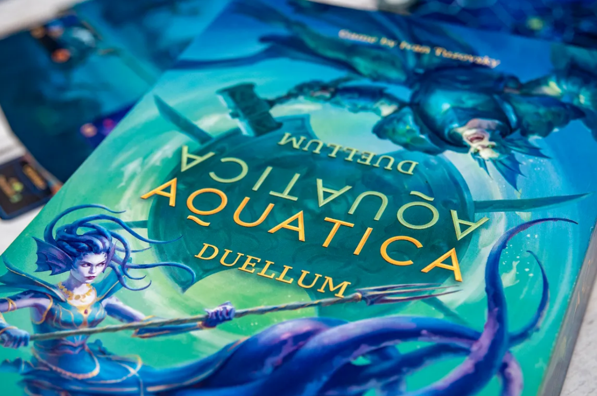 Aquatica Duellum board game cover featuring vibrant artwork of underwater characters and a mystical ocean backdrop.