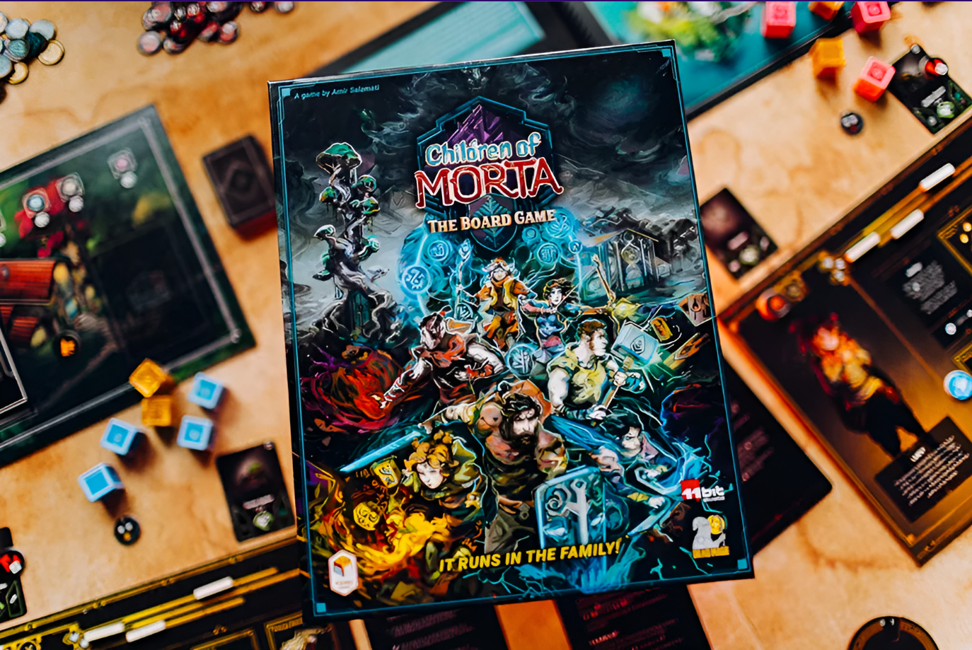 Children of Morta: The Board Game box displayed on a tabletop surrounded by game components and cards.