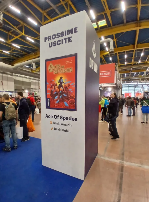 Promotional display for the board game "Ace of Spades" by Benja Amorin and David Rubin at a gaming convention.