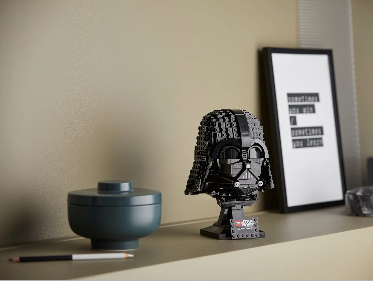 LEGO Star Wars Darth Vader Helmet set displayed on a shelf alongside a decorative bowl and framed artwork.