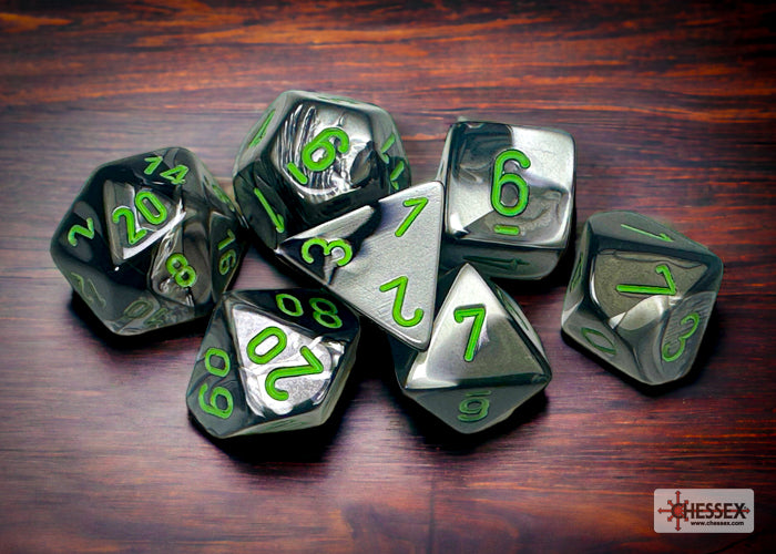 Chessex Gemini Black-Grey/Green 7-die set featuring metallic dice with green numbers on a wooden surface.