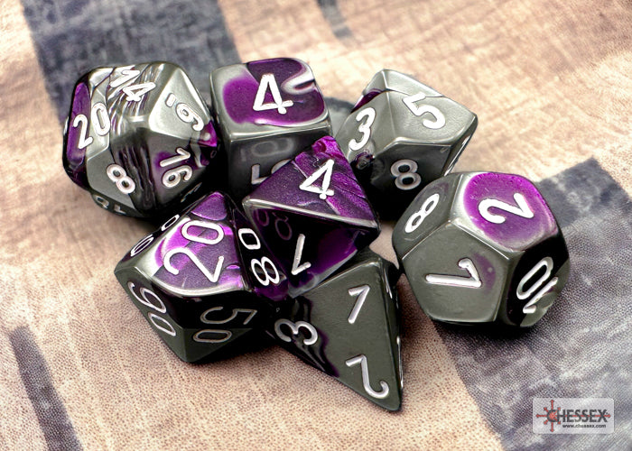 Chessex Gemini Purple-Steel/White 7-die set featuring vibrant purple and gray colors with white numbering.