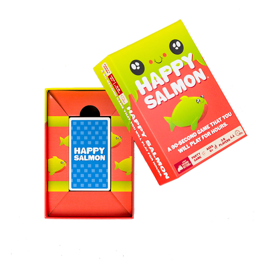 Colorful box of the game Happy Salmon, featuring a cheerful salmon graphic, with cards inside and vibrant packaging design.
