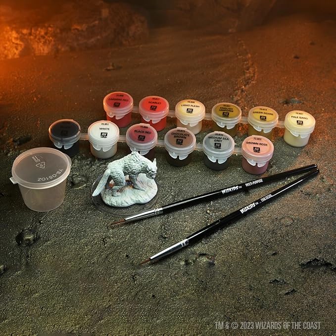 Dungeons & Dragons Yeth Hound mini with paint kit, featuring various paint pots and brushes on a textured surface.