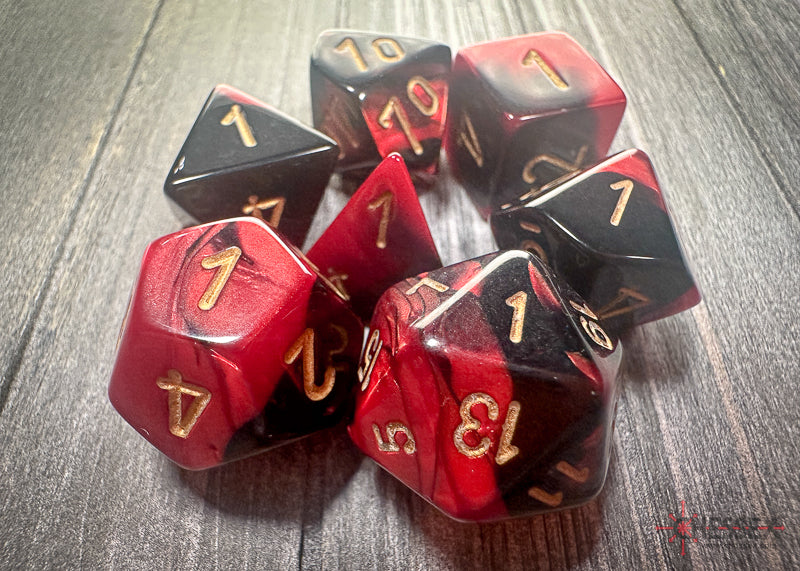 Chessex Gemini Black-Red/Gold polyhedral 7-dice set featuring vibrant colors and gold numbering on each die.