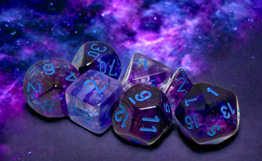 Chessex Nebula Nocturnal Blue Luminary 7 Die Set featuring vibrant blue numbers on translucent purple dice against a cosmic background.