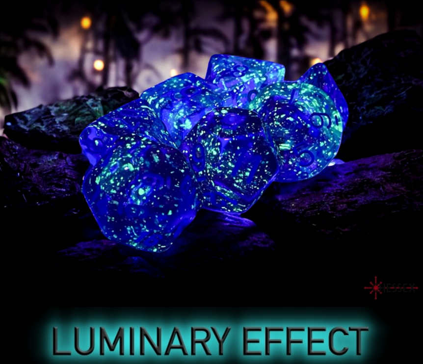 Chessex Nebula Nocturnal Blue Luminary 7 Die Set glowing with a starry effect, displayed on a textured surface.