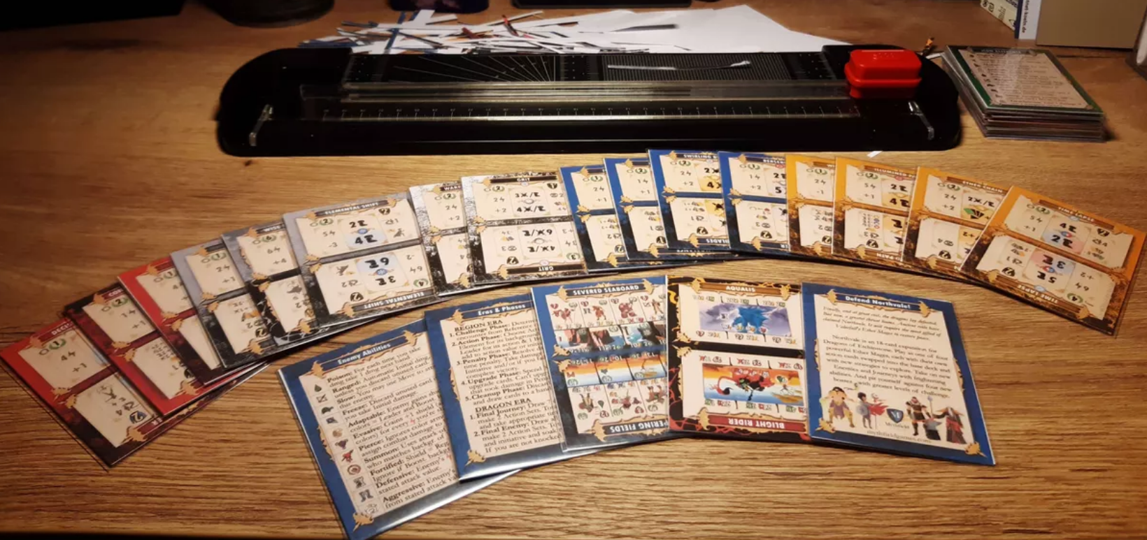 A collection of game cards from the Dragons of Etchinstone: Northvale Expansion, displayed on a wooden table.