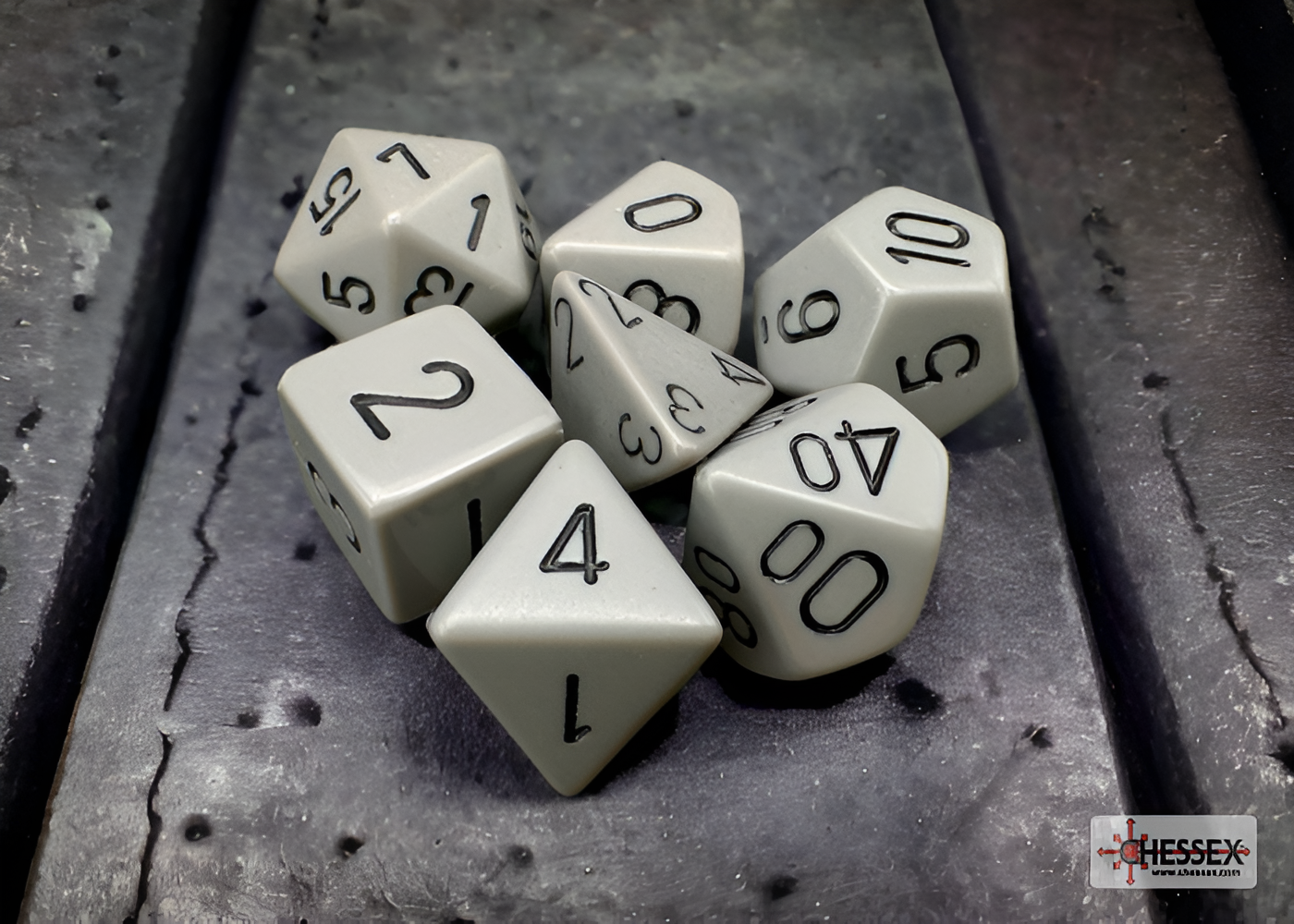 Opaque dark grey and black 7-die set from Chessex, featuring various polyhedral shapes for tabletop gaming.