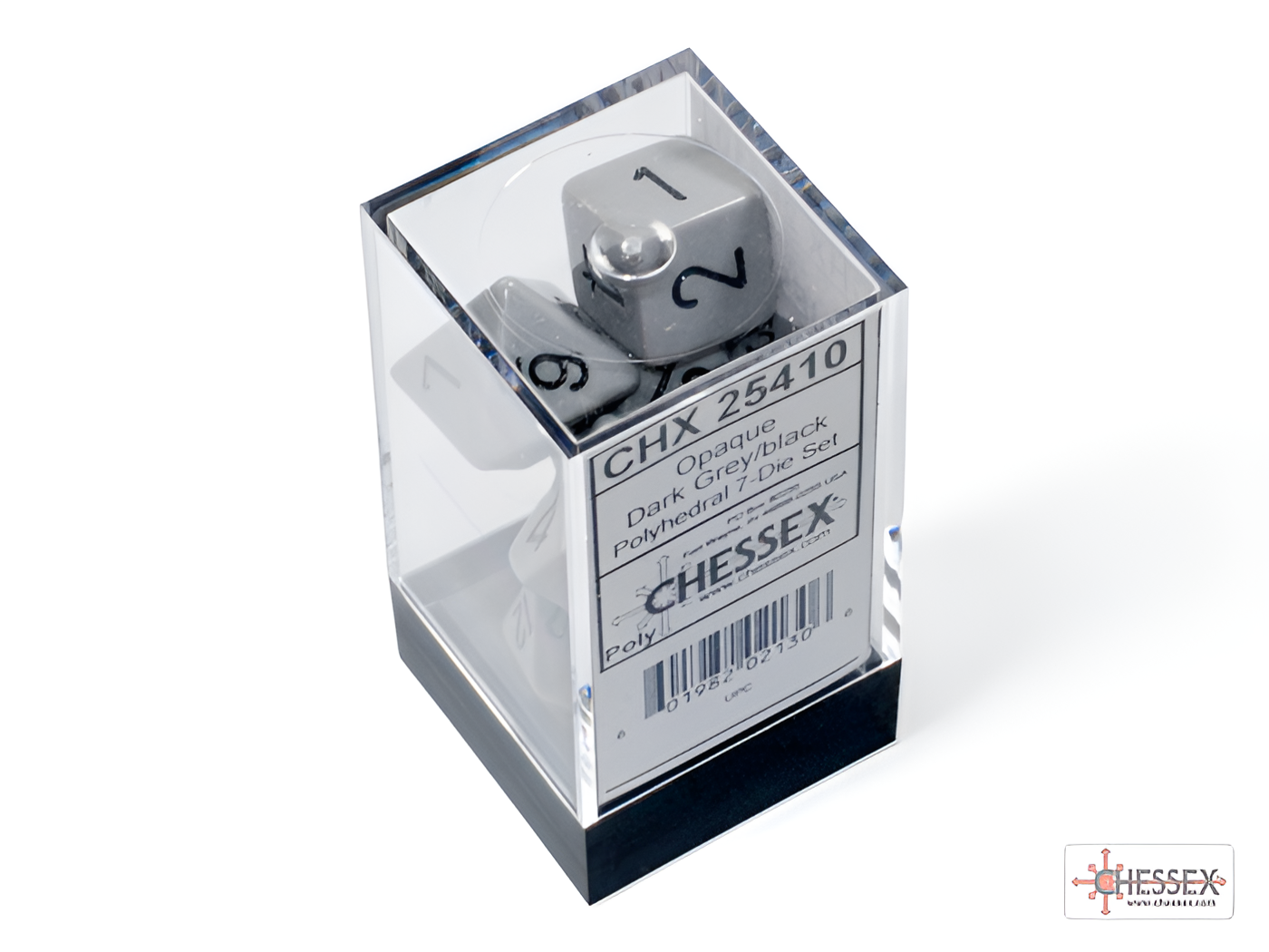 Chessex opaque dark grey and black 7-die set displayed in a clear plastic box, featuring dice with white numbers.