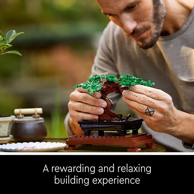 A person carefully assembles the LEGO Botanicals Bonsai Tree set, showcasing intricate details and vibrant green leaves.