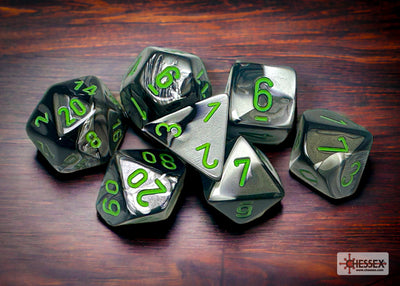 Chessex Gemini Black-Grey/Green 7-die set featuring metallic dice with green numbers on a wooden surface.