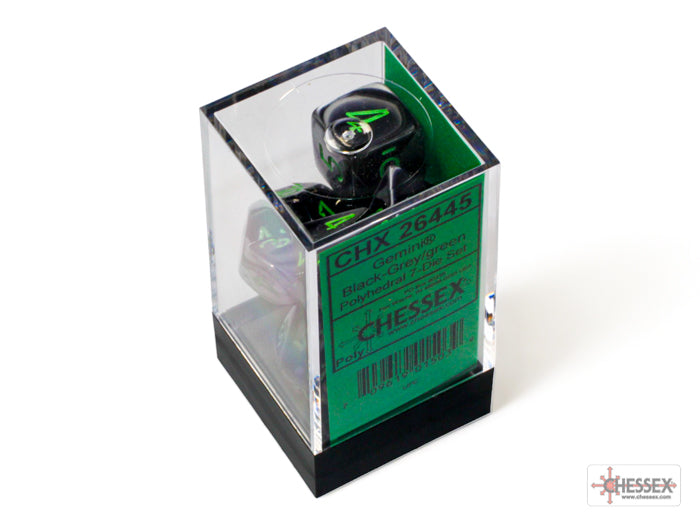 Chessex Gemini Black-Grey/Green 7-die set displayed in a clear box with a green label. Ideal for tabletop gaming.