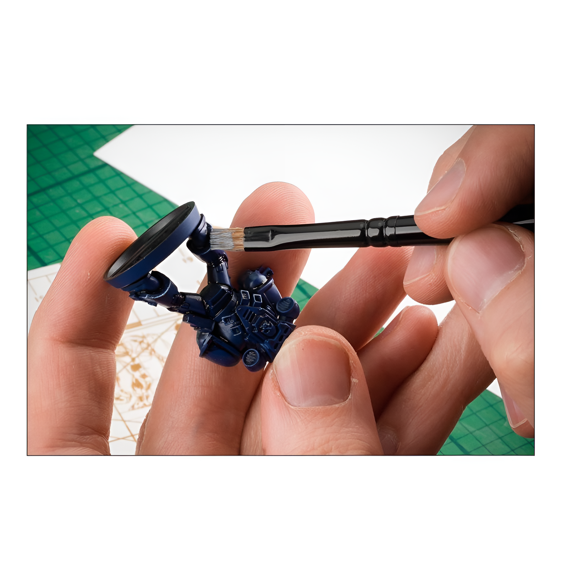 A person using a medium dry brush to paint details on a miniature figure, showcasing precision in tabletop gaming.