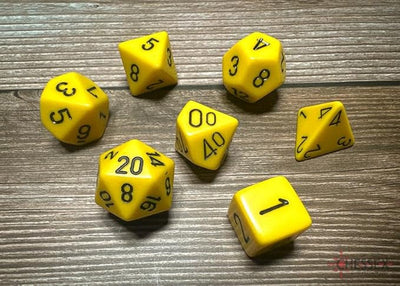 Chessex opaque yellow 7-die set featuring various dice including d4, d6, d8, d10, d12, d20, and percentile die.
