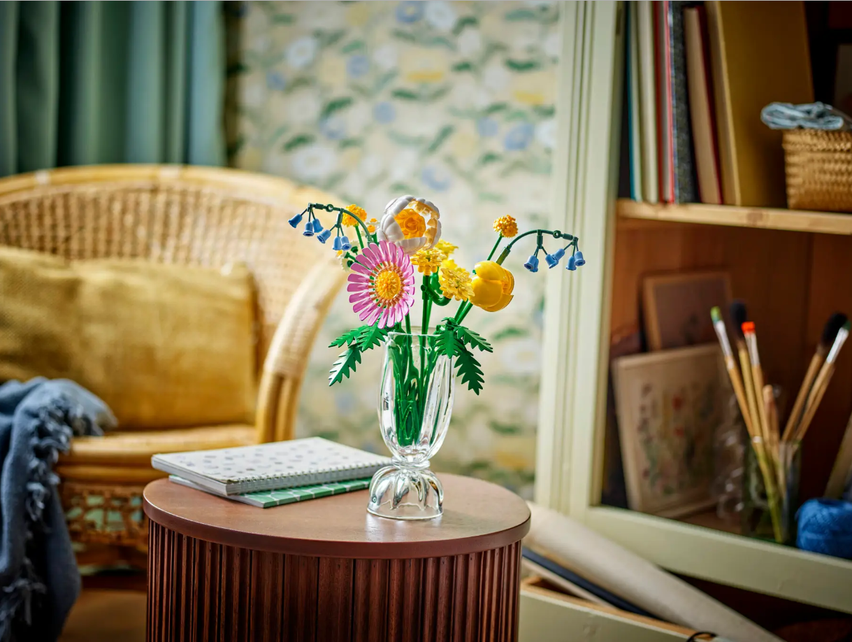 LEGO Petite Sunny Bouquet (10347) features colorful flower arrangements in a clear vase on a wooden table in a cozy setting.