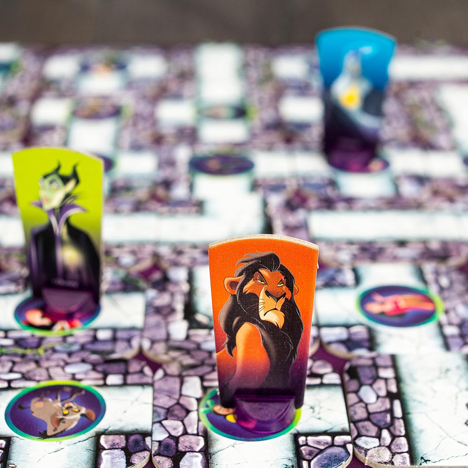 Colorful game board of Disney Villains: Labyrinth featuring character tokens like Maleficent and Scar among maze pathways.